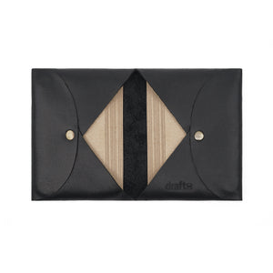 Open Draft-8 FOLD leather cardholder in black, displaying multiple stacked cards inside geometric V-shaped slots.
