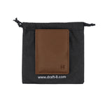 Load image into Gallery viewer, Brown Draft-8 leather wallet inside black fabric packaging pouch with visible brand logo.

