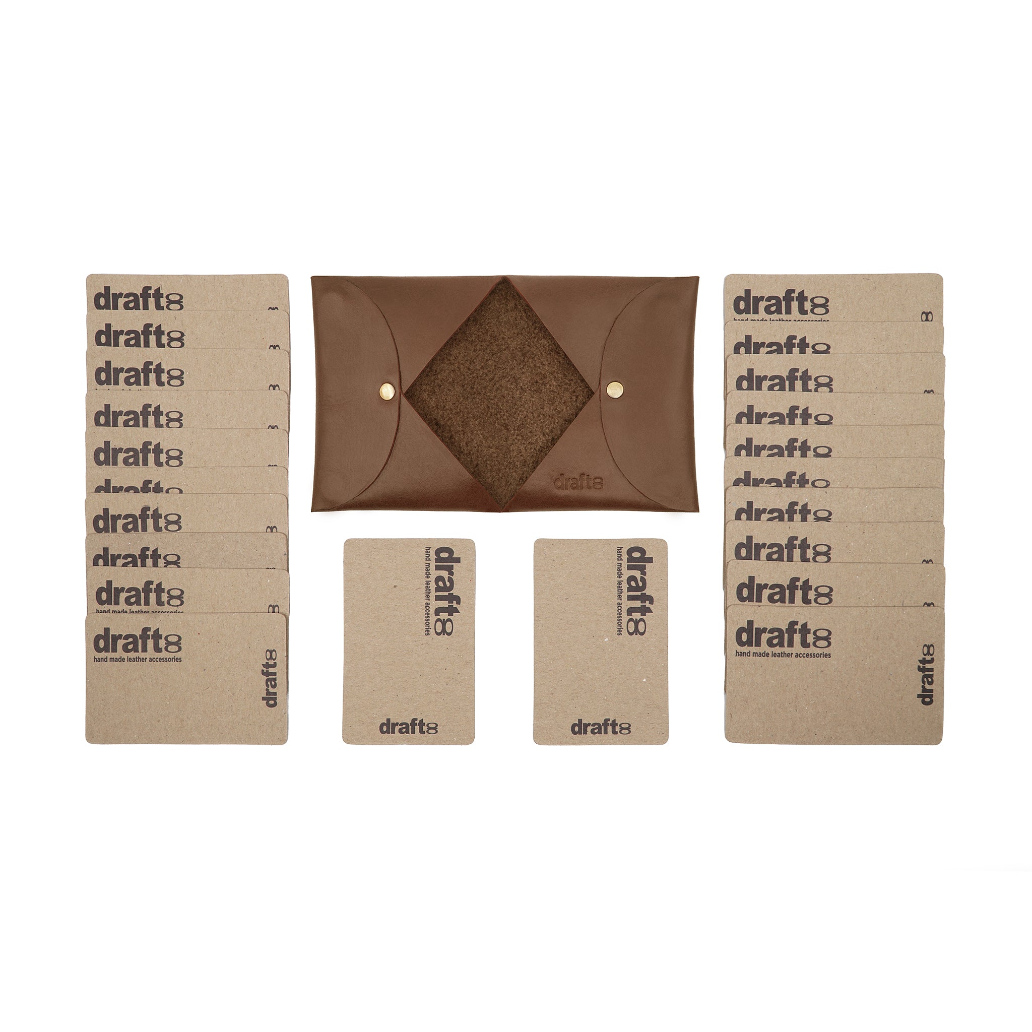 Open view of a brown vegetable-tanned leather cardholder by draft-8, displayed with cardboard sample cards