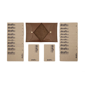 Open view of a brown vegetable-tanned leather cardholder by draft-8, displayed with cardboard sample cards
