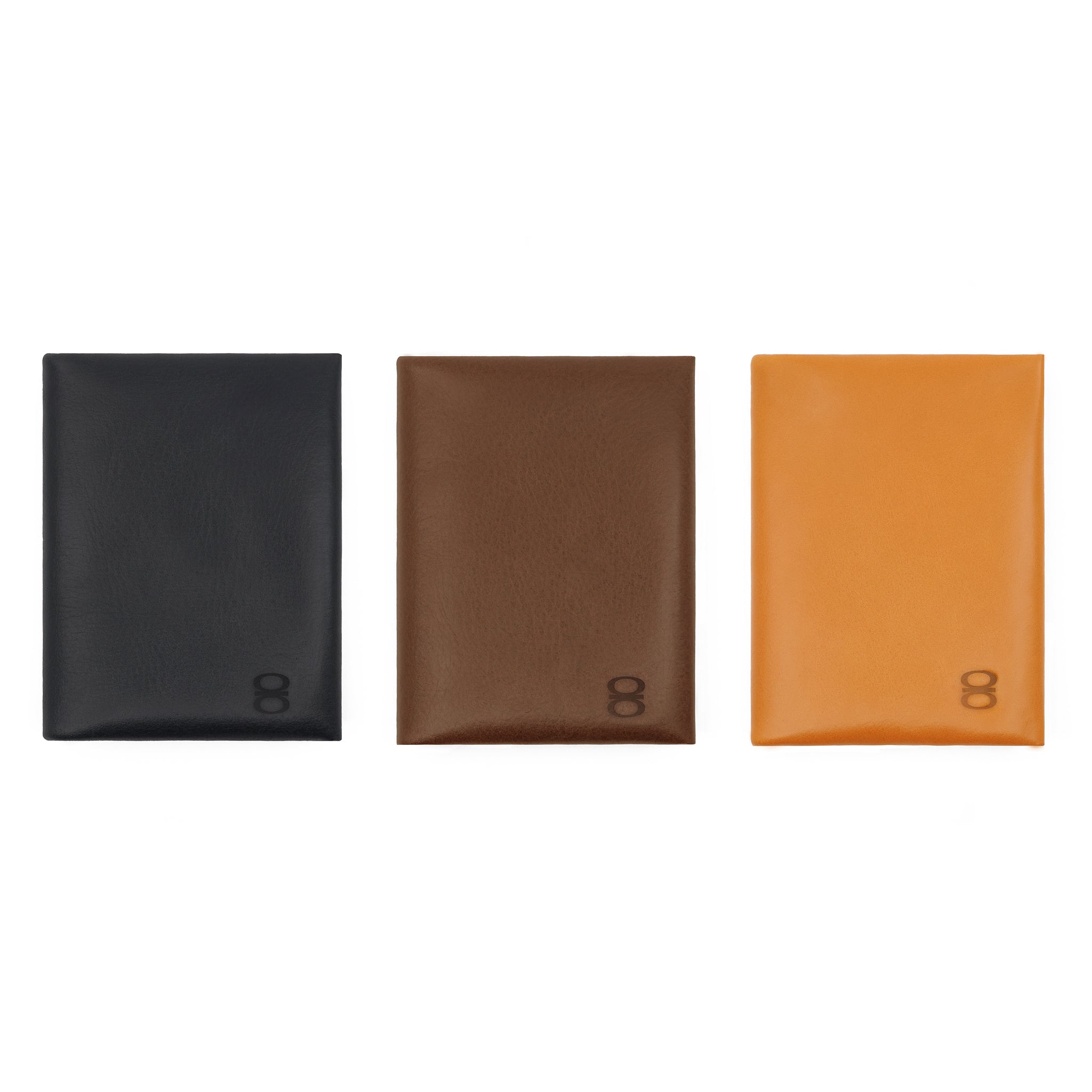 Three vegetable-tanned leather cardholders by draft-8 in black, brown, and camel, displayed side by side